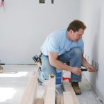 Electrician installing outlets on wall